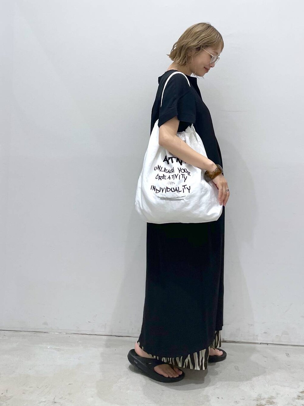 ブラック系のTシャツ/カットソー、ブラック系のワンピース、ホワイト系のショルダーバッグを着用したレディースの夏コーディネートの3枚目の写真