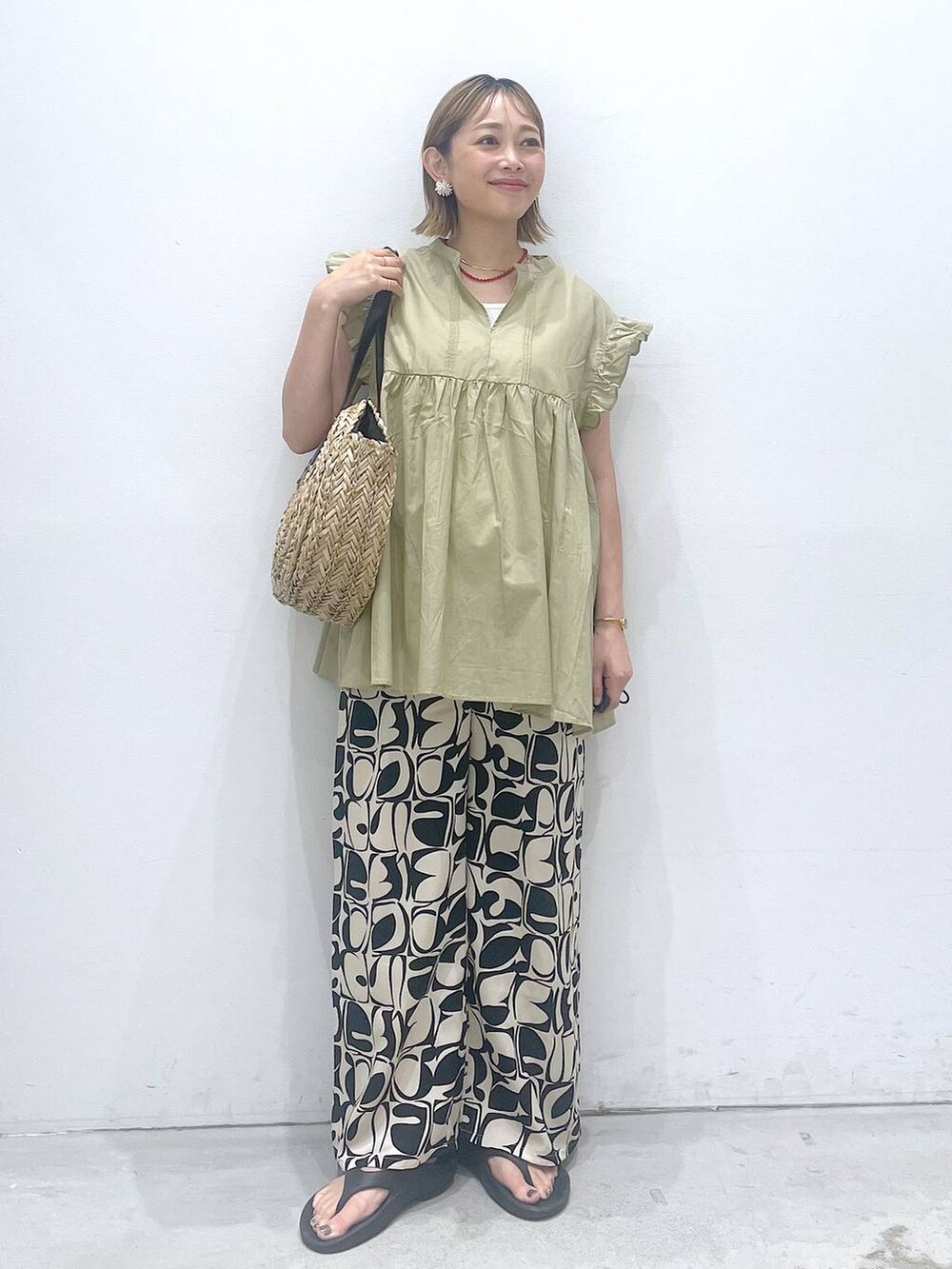 ホワイト系のタンクトップ、ブラック系のショルダーバッグ、ベージュ系のシャツ/ブラウスを着用したレディースの夏コーディネートの4枚目の写真