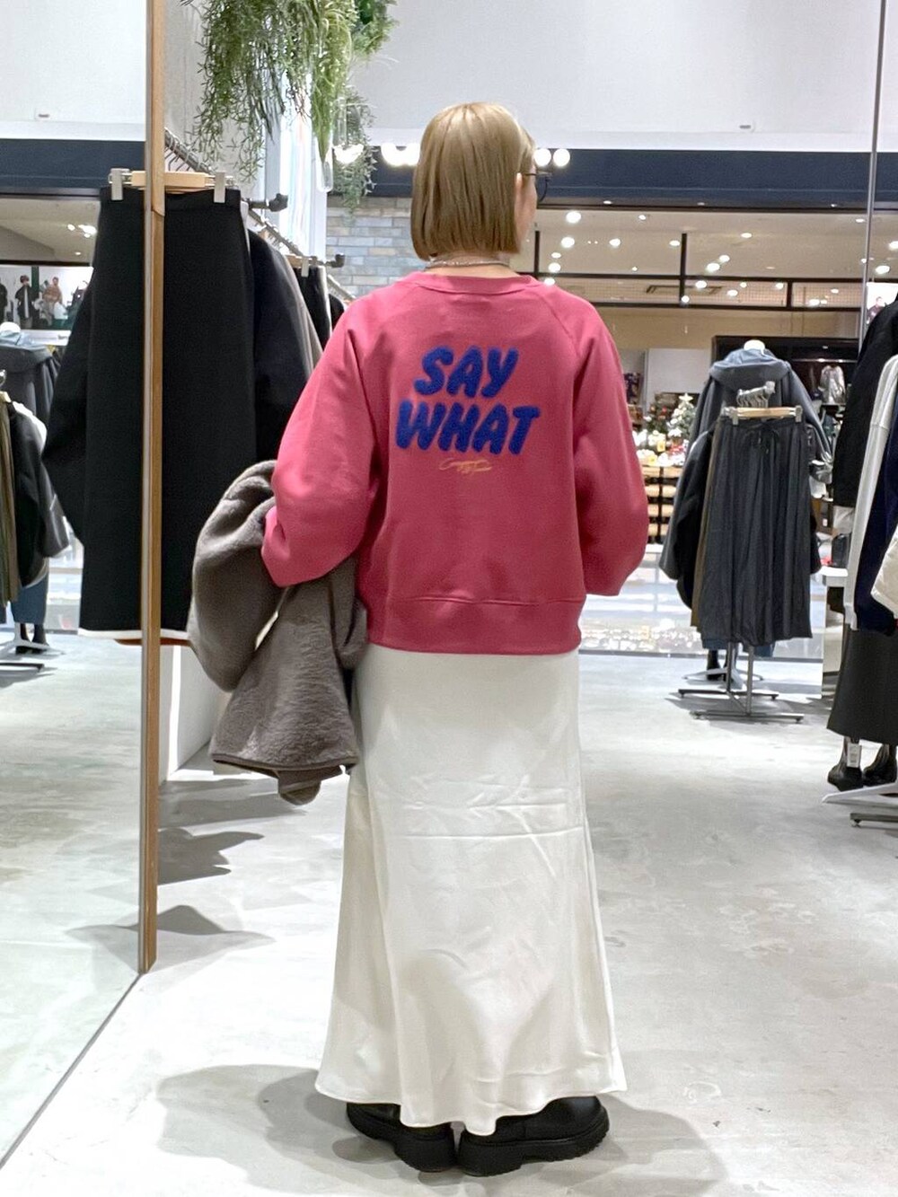 ブラック系のショルダーバッグ、ホワイト系のスカート、ブラウン系のその他アウターを着用したレディースの秋コーディネートの3枚目の写真