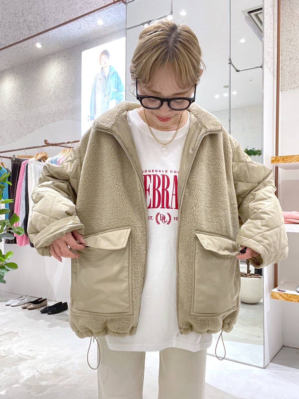 ベージュ系のブルゾン、ホワイト系のスニーカー、ホワイト系のその他パンツを着用したレディースの秋コーディネートの2枚目の写真