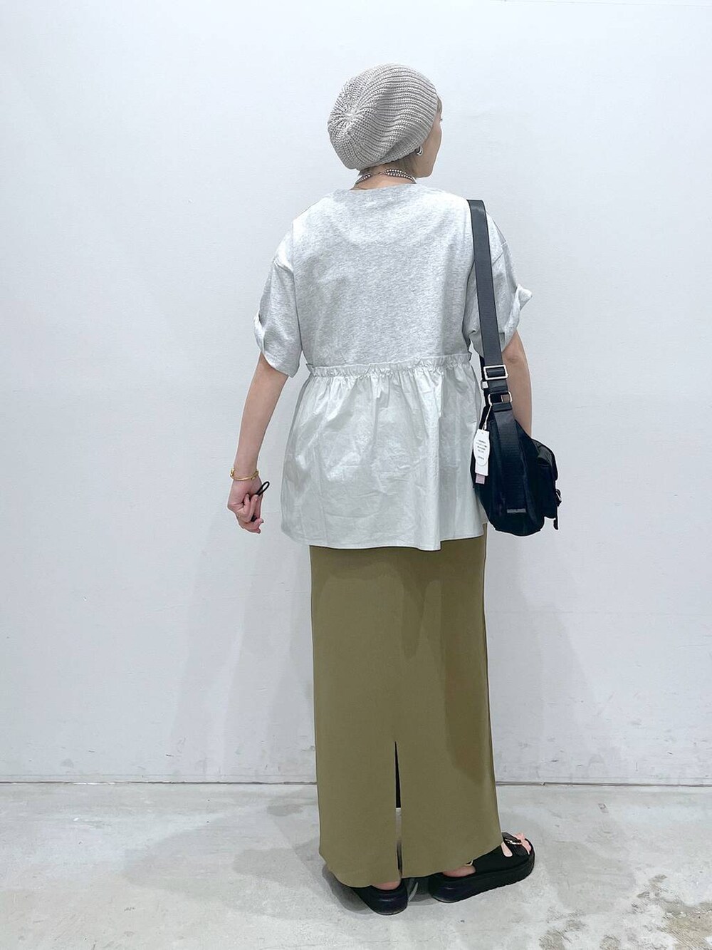 グリーン系のスカート、ブラック系のショルダーバッグ、ブラック系のサンダルを着用したレディースの春コーディネートの3枚目の写真