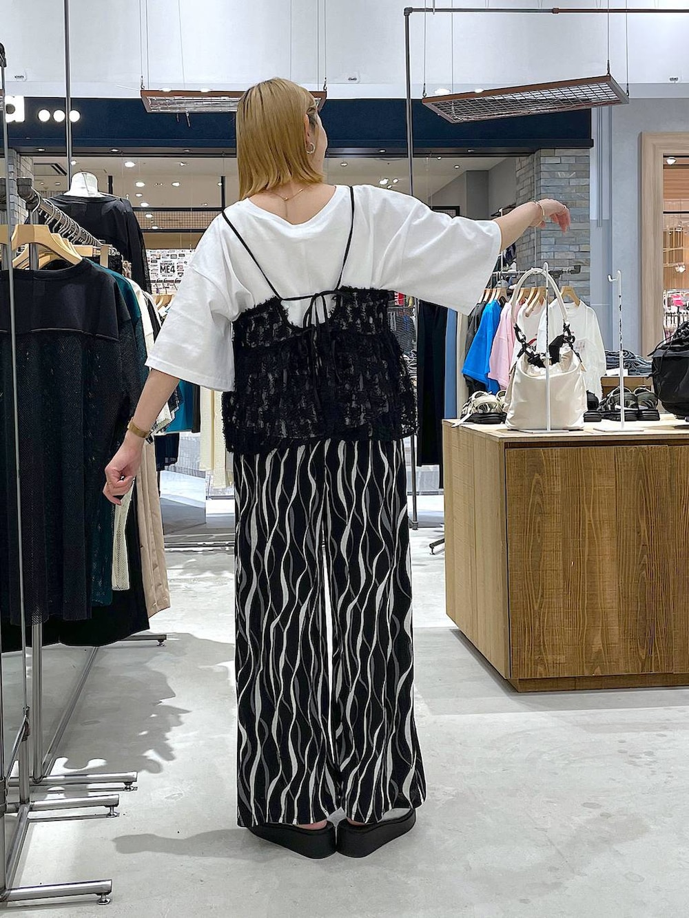 ホワイト系のTシャツ/カットソー、シルバー系のサンダル、ブラック系のその他パンツを着用したレディースの夏コーディネートの2枚目の写真