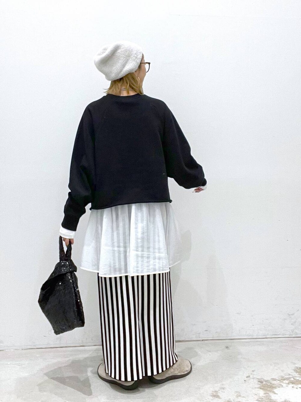 ブラック系のスカート、ブラック系のTシャツ/カットソー、ホワイト系のTシャツ/カットソーを着用したレディースの秋コーディネートの3枚目の写真