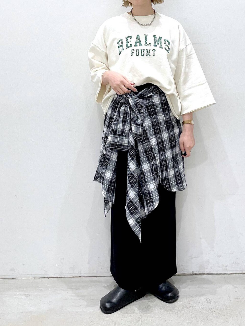 ブラック系のスカート、ブラック系のサンダル、ブラック系のシャツ/ブラウスを着用したレディースの春コーディネートの3枚目の写真