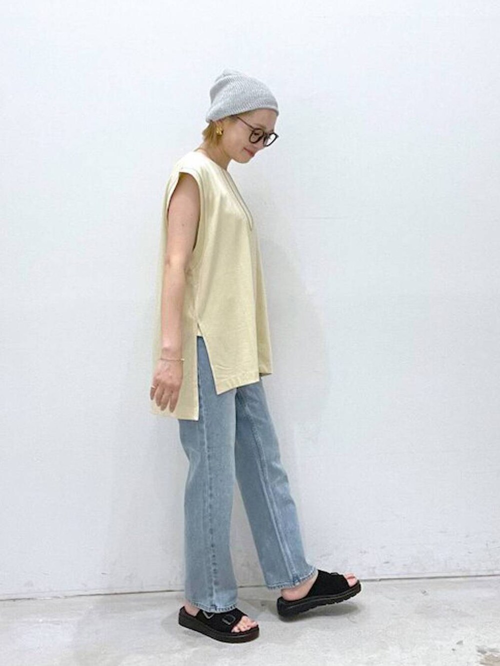 ベージュ系のTシャツ/カットソー、ブラック系のサンダル、ホワイト系のタンクトップを着用したレディースの夏コーディネートの2枚目の写真