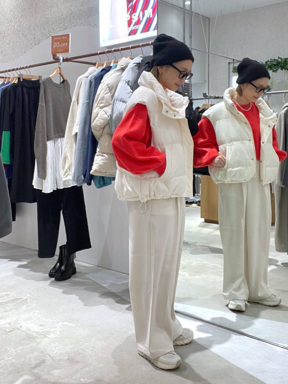 ホワイト系のダウンベスト、レッド系のニット/セーター、ホワイト系のその他パンツを着用したレディースの秋コーディネートの2枚目の写真