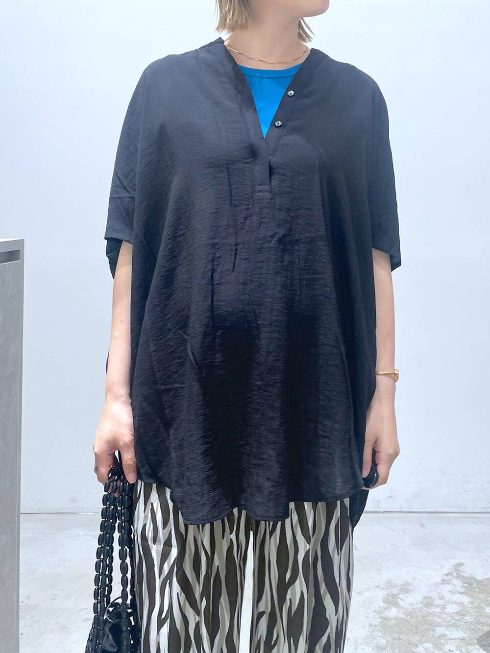 ブルー系のTシャツ/カットソー、ブラック系のハンドバッグ、ブラック系のチュニックを着用したレディースの夏コーディネートの6枚目の写真