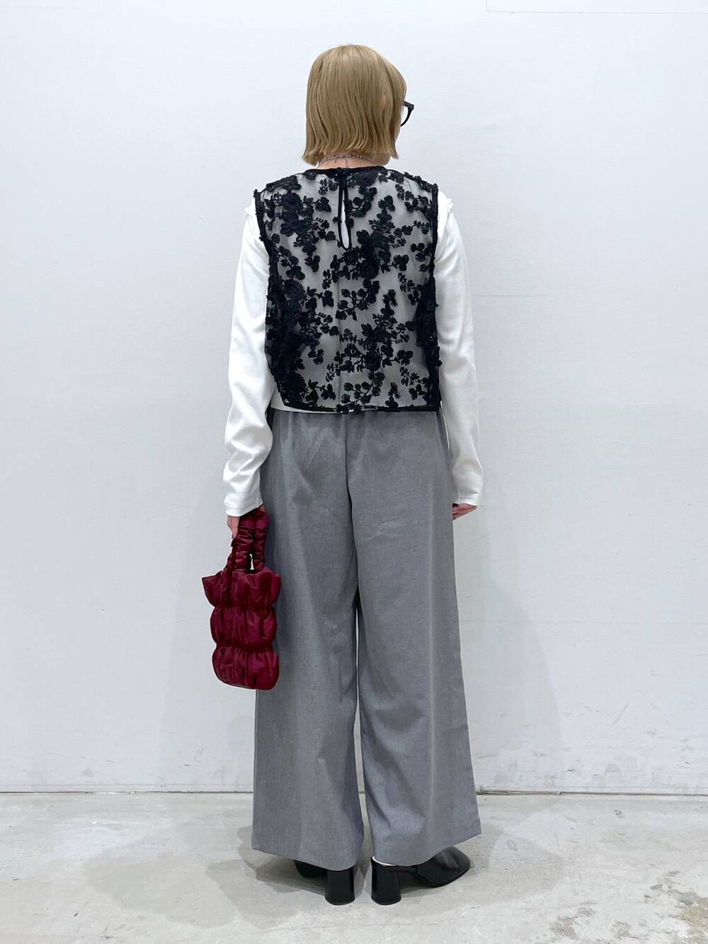 グレー系のその他パンツ、ホワイト系のTシャツ/カットソー、レッド系のショルダーバッグを着用したレディースの冬コーディネートの3枚目の写真