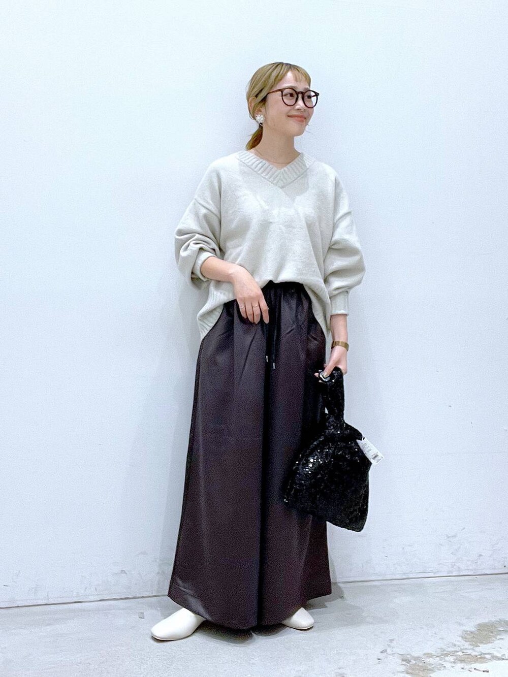 ホワイト系のニット/セーター、ホワイト系のブーツ、グレー系のその他パンツを着用したレディースの秋コーディネートの4枚目の写真