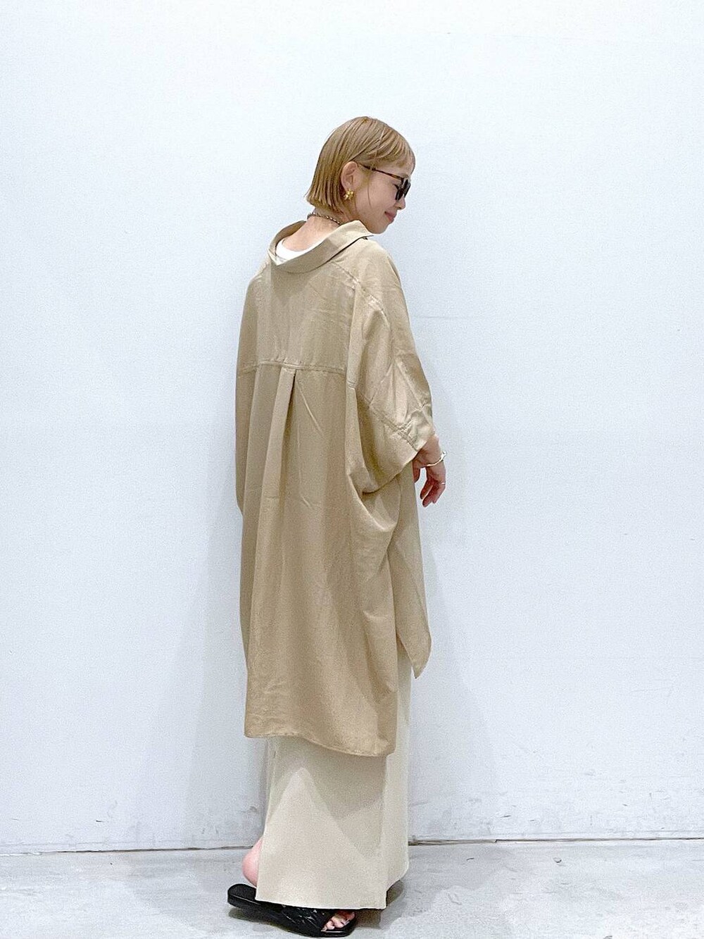 ブラック系のサンダル、ベージュ系のスカート、ベージュ系のチュニックを着用したレディースの夏コーディネートの2枚目の写真