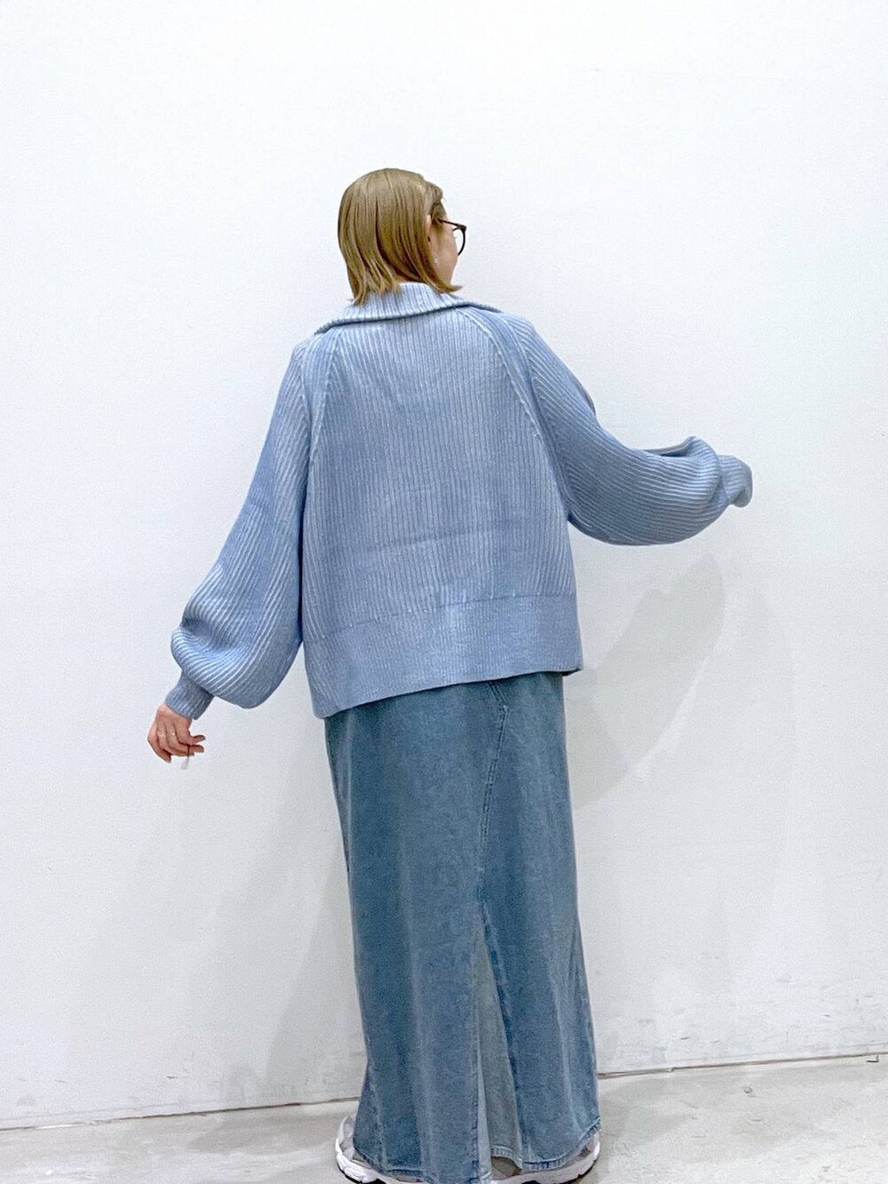 ブルー系のカーディガン/ボレロ、グレー系のスニーカー、ブルー系のジャンパースカートを着用したレディースの秋コーディネートの3枚目の写真