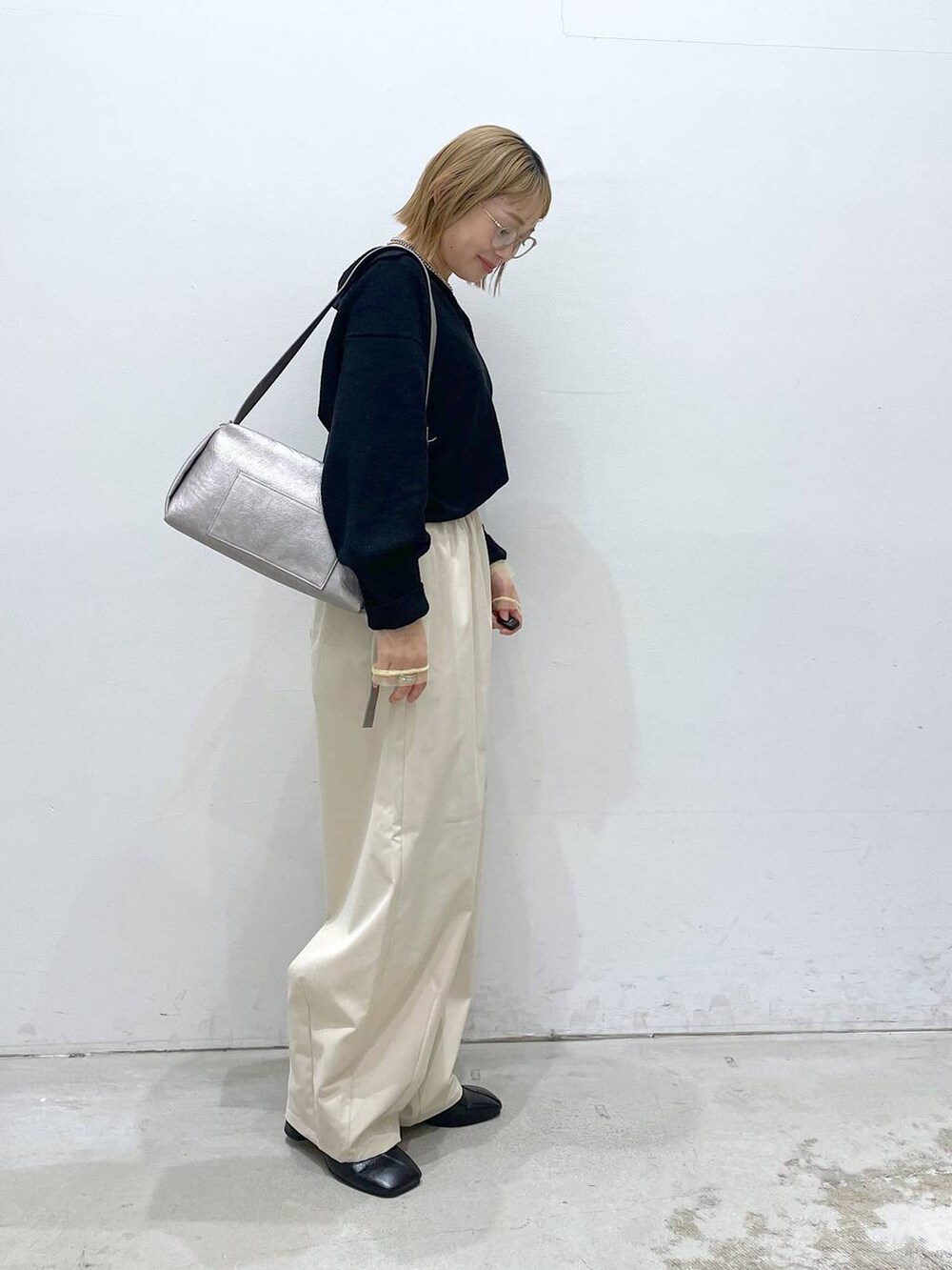 ホワイト系のTシャツ/カットソー、グレー系のショルダーバッグ、ブラック系のパンプスを着用したレディースの冬コーディネートの2枚目の写真