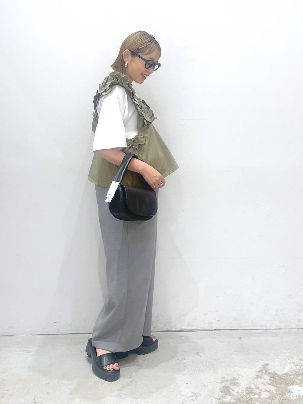 ブラック系のハンドバッグ、ブラウン系のサンダル、グレー系のその他パンツを着用したレディースの夏コーディネートの2枚目の写真