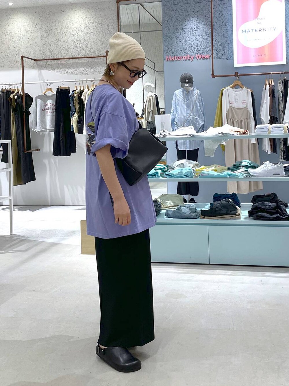 ブラック系のショルダーバッグ、ブラック系のスカート、ブラック系のサンダルを着用したレディースの春コーディネートの2枚目の写真