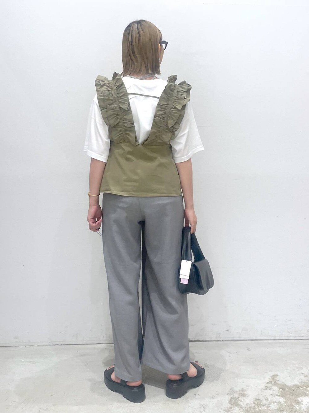 ブラック系のハンドバッグ、ブラウン系のサンダル、グレー系のその他パンツを着用したレディースの夏コーディネートの3枚目の写真