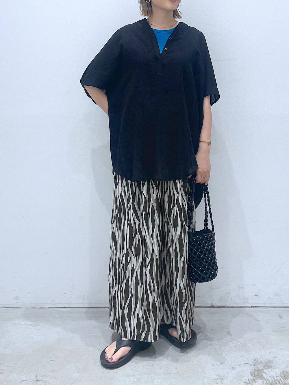 ブルー系のTシャツ/カットソー、ブラック系のハンドバッグ、ブラック系のチュニックを着用したレディースの夏コーディネートの5枚目の写真