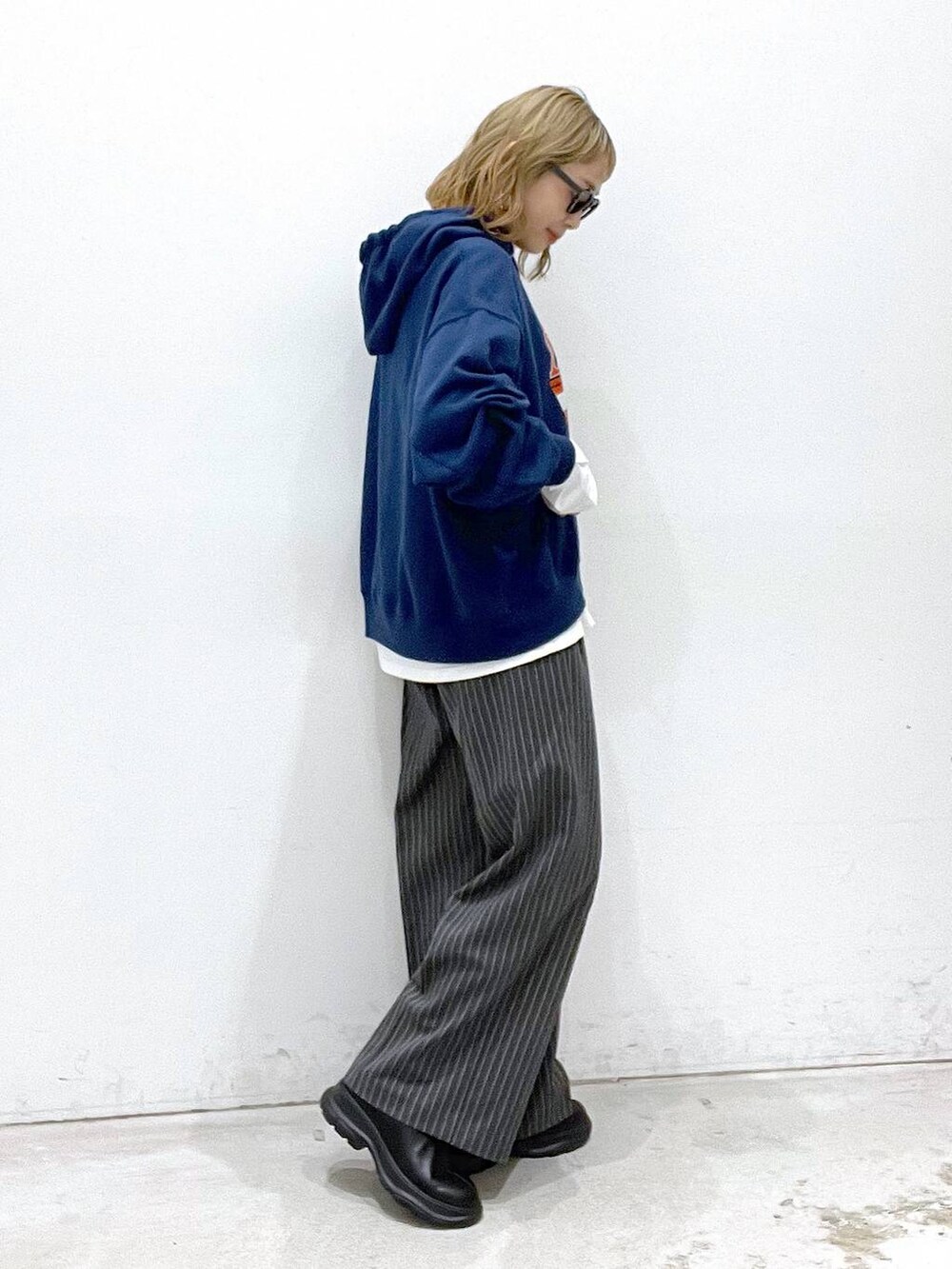 ホワイト系のTシャツ/カットソー、ブラック系のブーツ、ブルー系のパーカーを着用したレディースの秋コーディネートの2枚目の写真