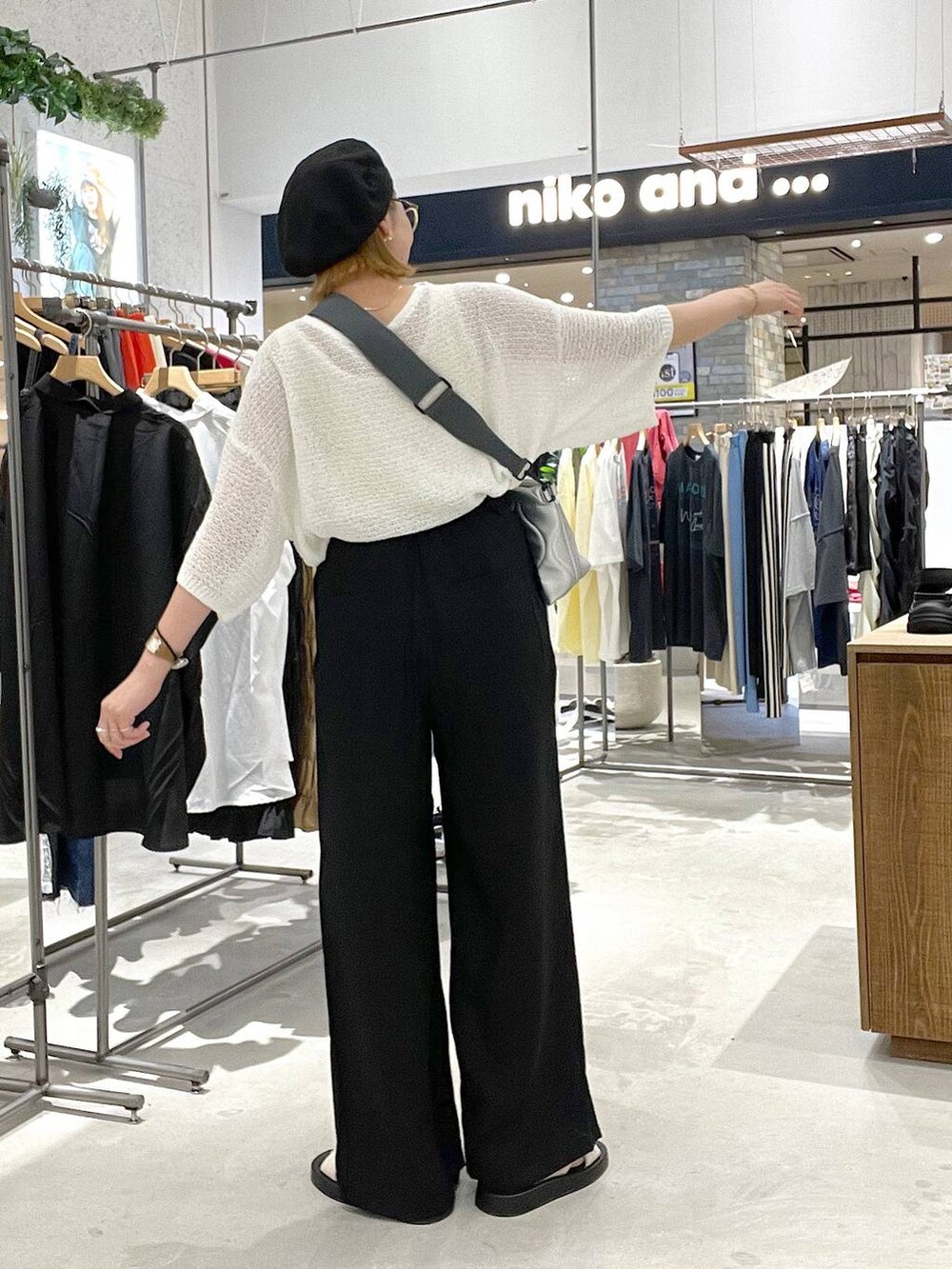 ブラック系のその他パンツ、ホワイト系のサンダル、シルバー系のクラッチバッグを着用したレディースの夏コーディネートの3枚目の写真