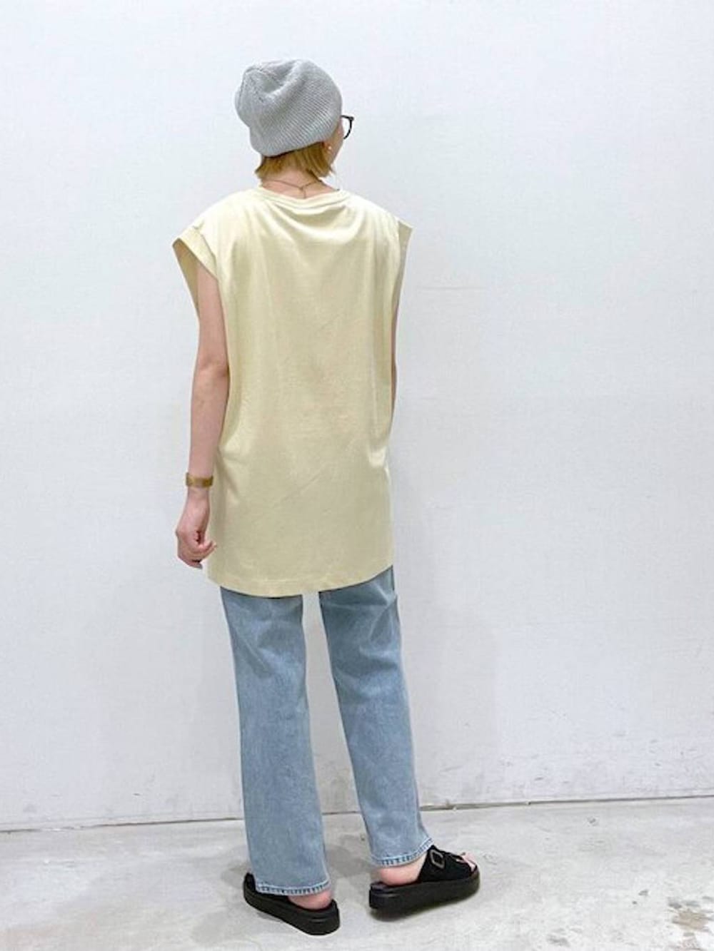 ベージュ系のTシャツ/カットソー、ブラック系のサンダル、ホワイト系のタンクトップを着用したレディースの夏コーディネートの3枚目の写真