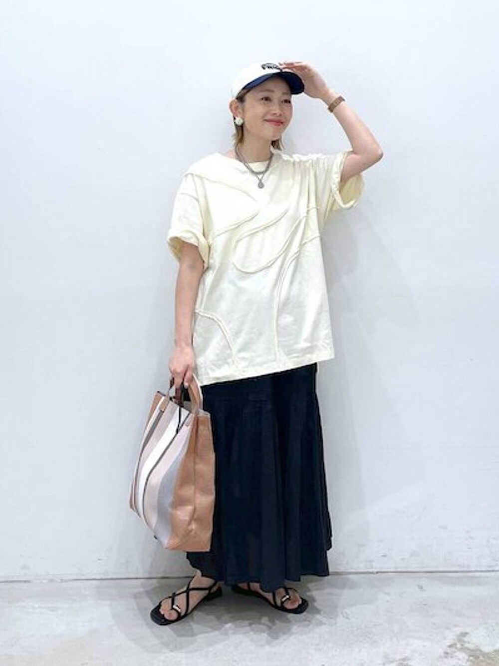 ブラック系のスカート、ブラック系のサンダル、グリーン系のTシャツ/カットソーを着用したレディースの春コーディネートの3枚目の写真