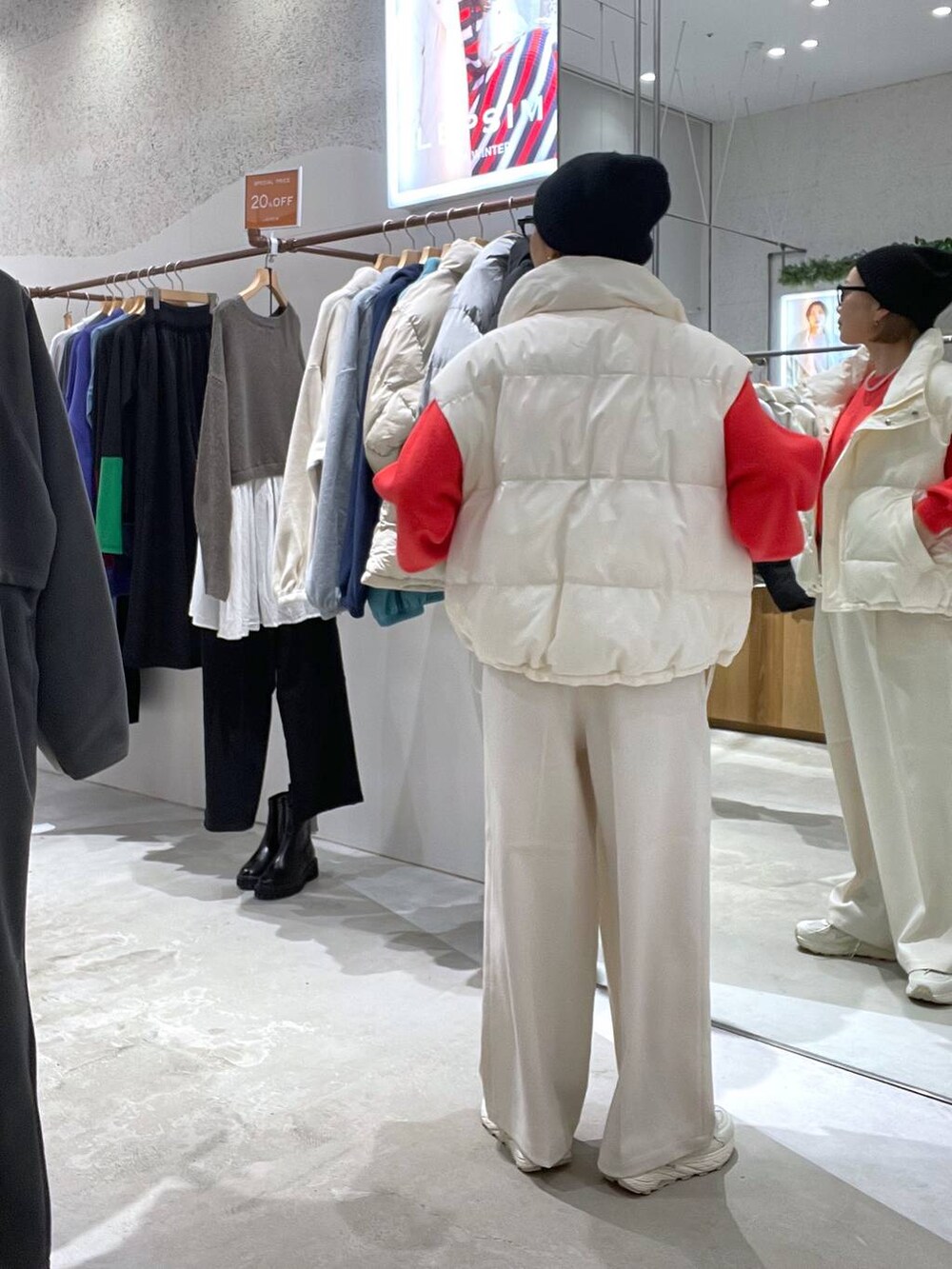 ホワイト系のダウンベスト、レッド系のニット/セーター、ホワイト系のその他パンツを着用したレディースの秋コーディネートの3枚目の写真