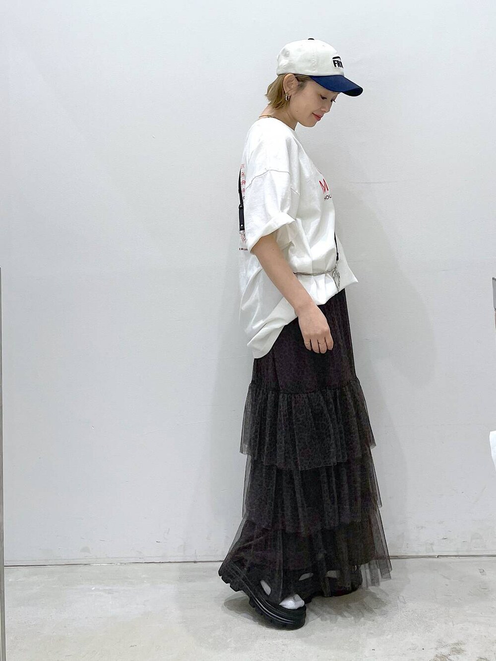 ブラック系のサンダル、ベージュ系のスカート、ホワイト系のTシャツ/カットソーを着用したレディースの春コーディネートの2枚目の写真