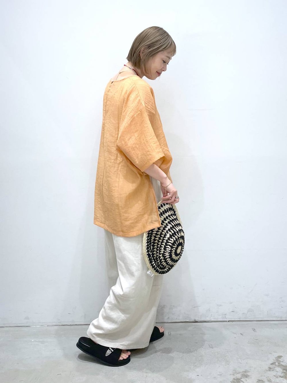 ホワイト系のタンクトップ、ホワイト系のその他パンツ、オレンジ系のシャツ/ブラウスを着用したレディースの夏コーディネートの2枚目の写真