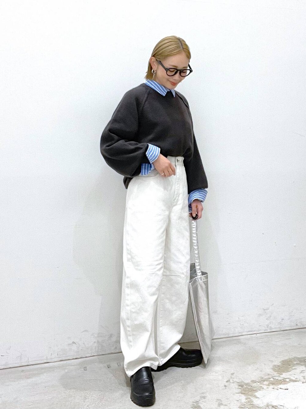 シルバー系のトートバッグ、グレー系のニット/セーター、ホワイト系のデニムパンツを着用したレディースの冬コーディネートの5枚目の写真