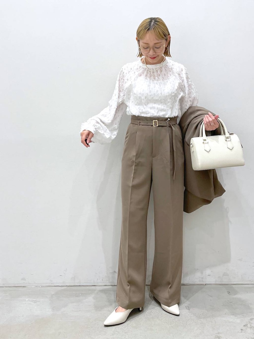 ブラウン系のスーツパンツ、ホワイト系のシャツ/ブラウス、ホワイト系のパンプスを着用したレディースの冬コーディネートの4枚目の写真