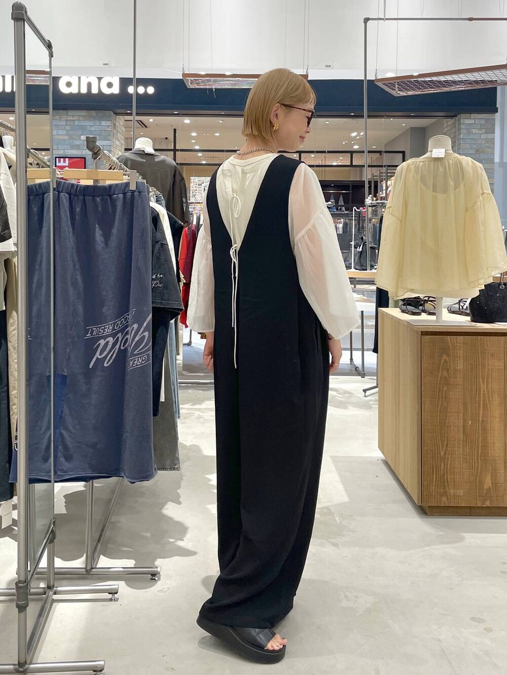 ホワイト系のシャツ/ブラウス、ブラック系のサロペット/オーバーオール、ブラック系のサンダルを着用したレディースの夏コーディネートの2枚目の写真