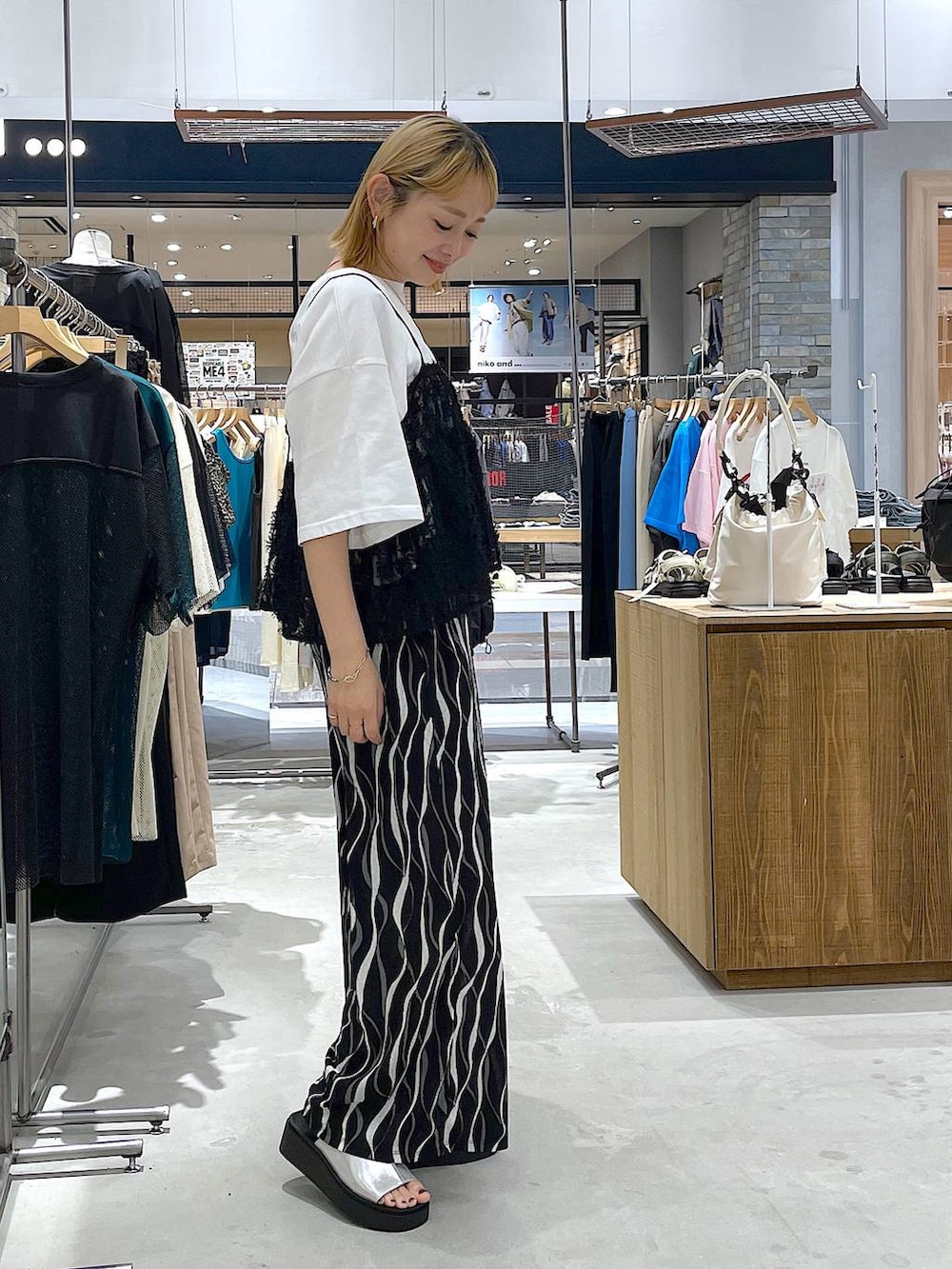 ホワイト系のTシャツ/カットソー、シルバー系のサンダル、ブラック系のその他パンツを着用したレディースの夏コーディネートの3枚目の写真