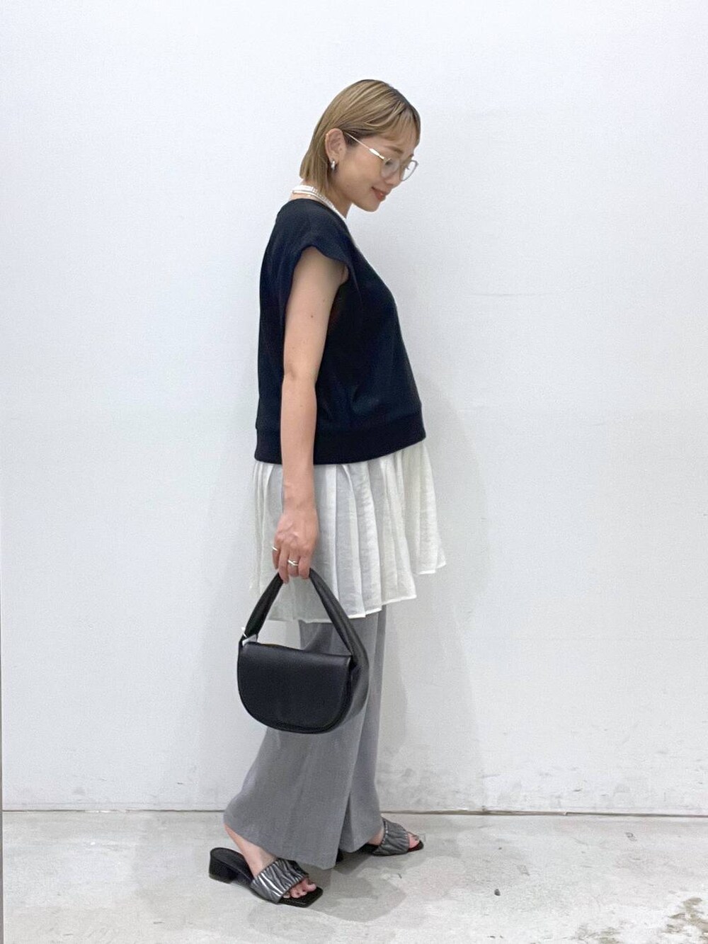 ブラック系のハンドバッグ、グレー系のその他パンツ、シルバー系のサンダルを着用したレディースの夏コーディネートの2枚目の写真