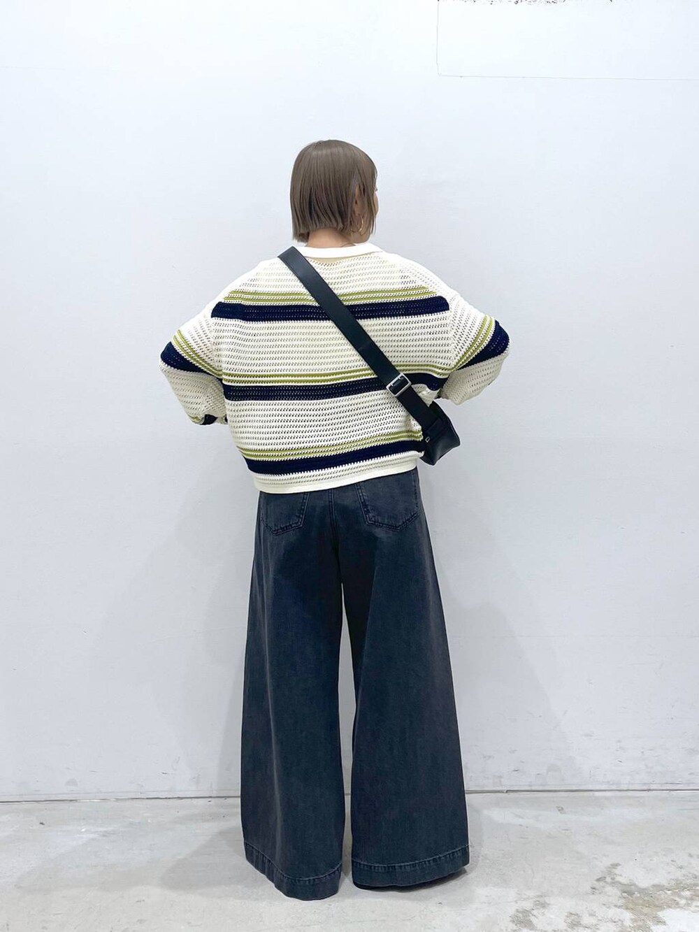 ホワイト系のTシャツ/カットソー、ホワイト系のニット/セーター、ブラック系のショルダーバッグを着用したレディースの春コーディネートの3枚目の写真