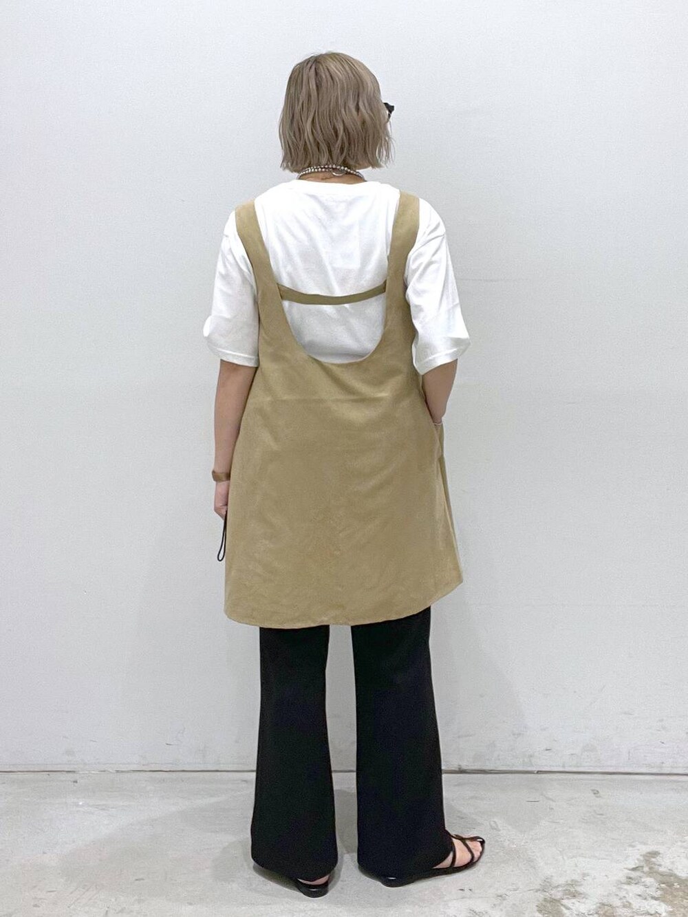 ブラック系のサンダル、ブラック系のその他パンツ、ベージュ系のチュニックを着用したレディースの夏コーディネートの3枚目の写真