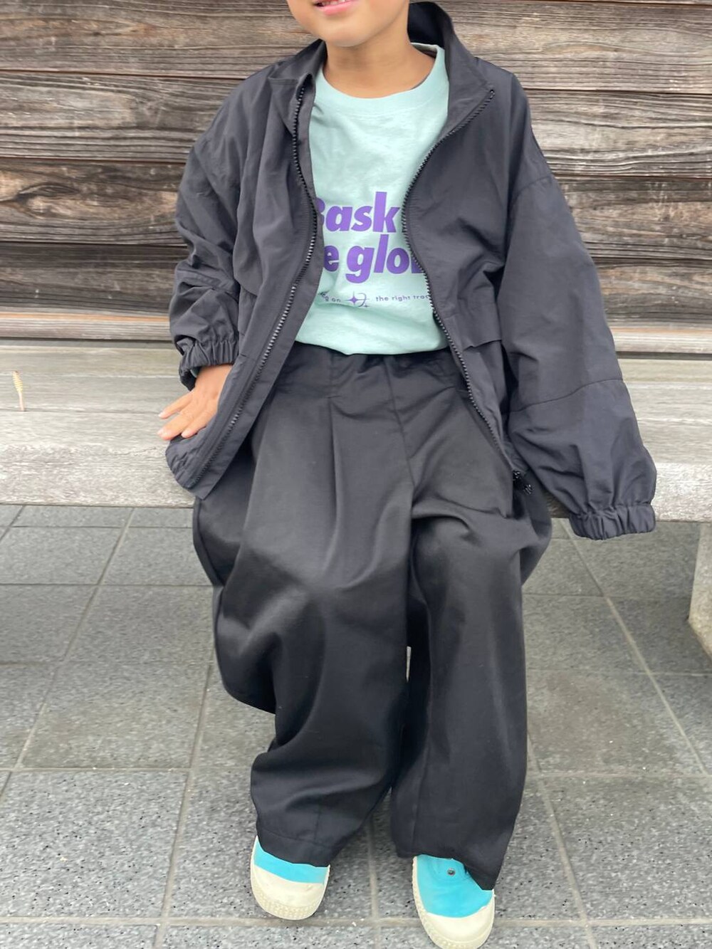 グレー系のブルゾン、ブラック系のその他パンツ、ブルー系のTシャツ/カットソーを着用したレディースの春コーディネートの2枚目の写真