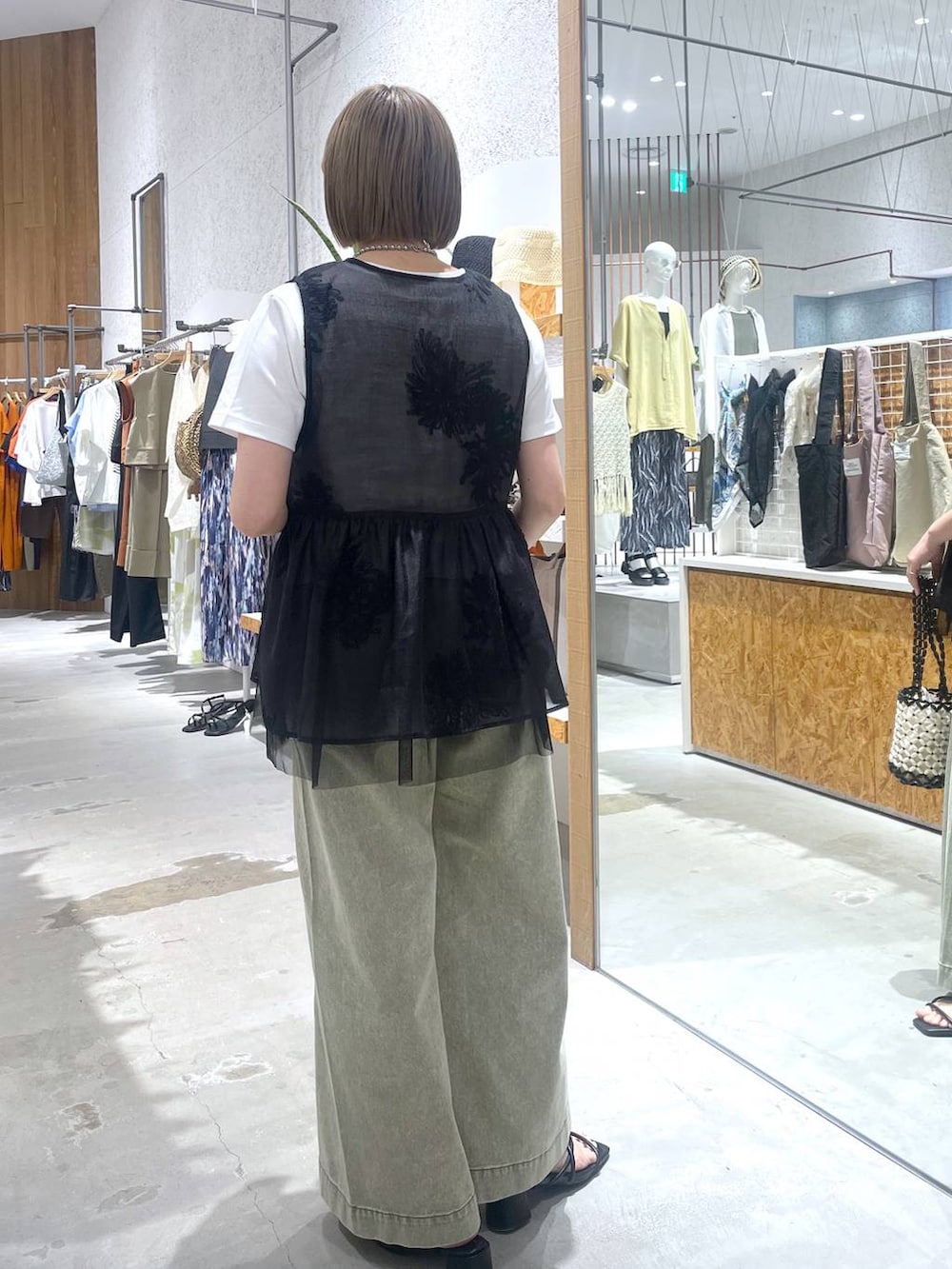 ホワイト系のTシャツ/カットソー、グリーン系のデニムパンツ、ブラック系のサンダルを着用したレディースの夏コーディネートの3枚目の写真