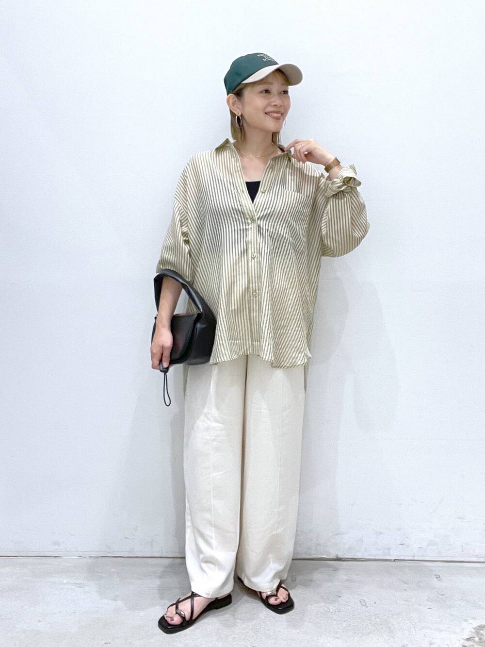 ホワイト系のその他パンツ、ブラック系のハンドバッグ、ブラック系のサンダルを着用したレディースの夏コーディネートの2枚目の写真