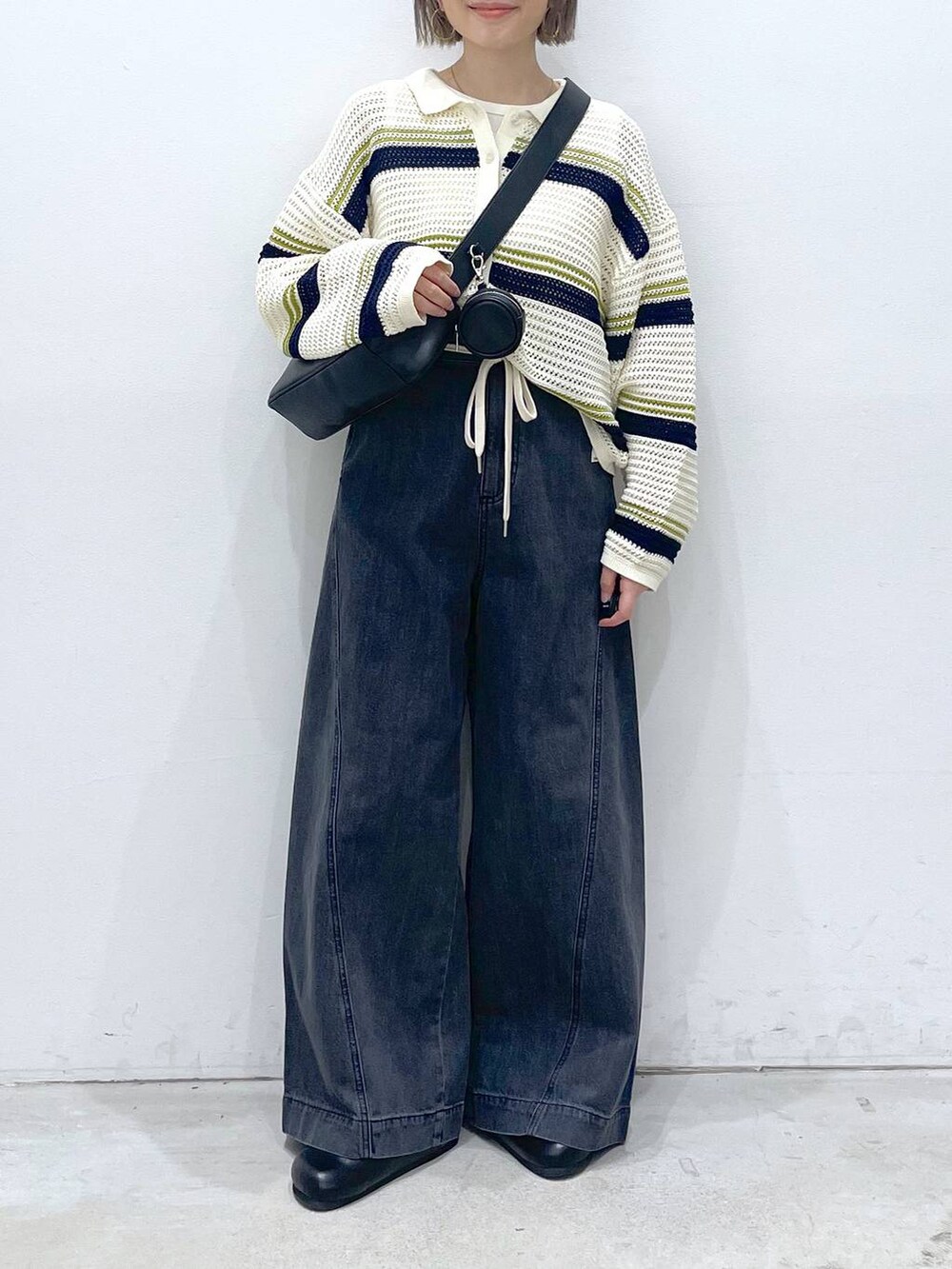 ホワイト系のTシャツ/カットソー、ホワイト系のニット/セーター、ブラック系のショルダーバッグを着用したレディースの春コーディネートの4枚目の写真