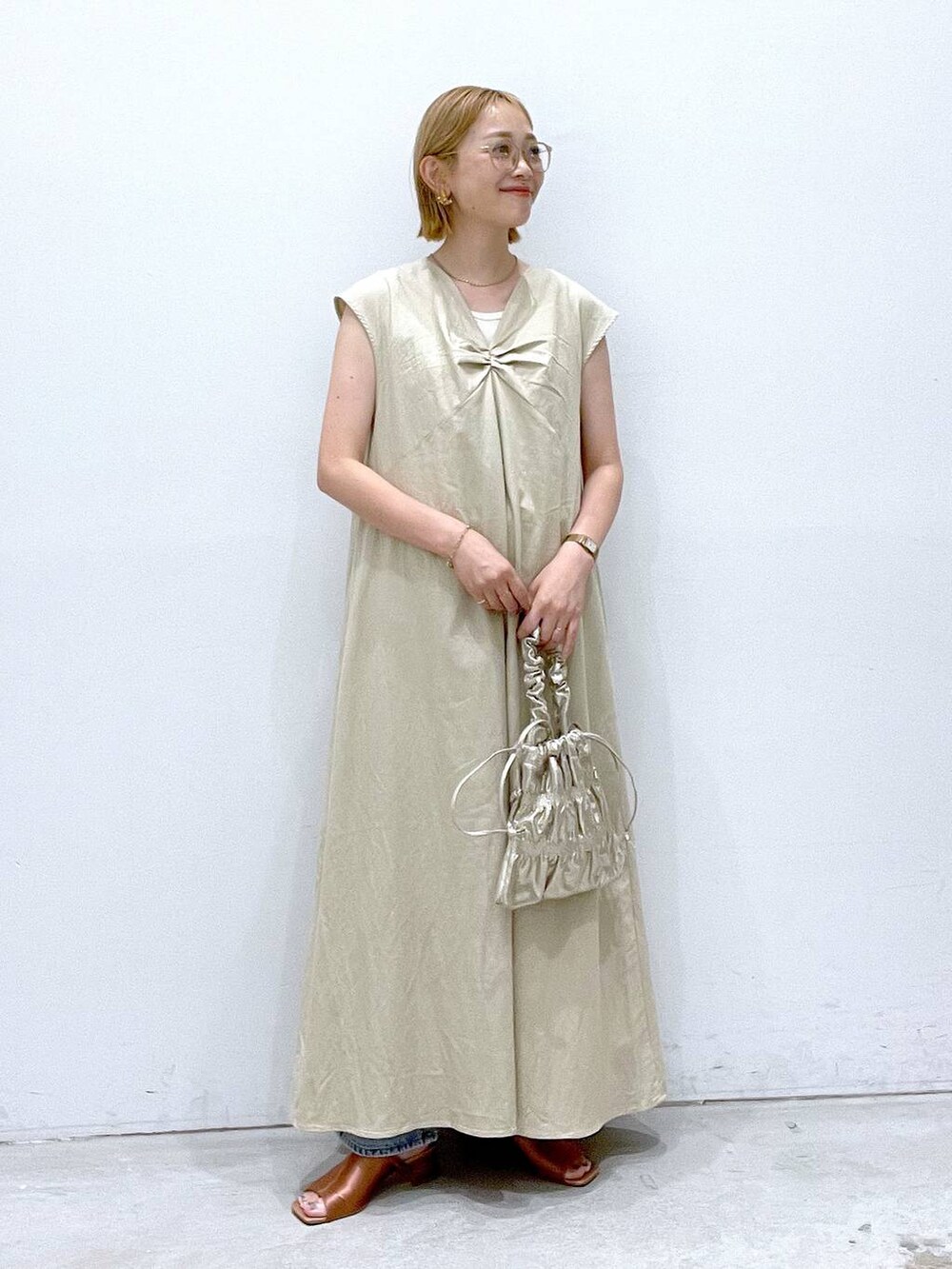 ホワイト系のワンピース、ホワイト系のタンクトップ、ゴールド系のショルダーバッグを着用したレディースの夏コーディネートの4枚目の写真