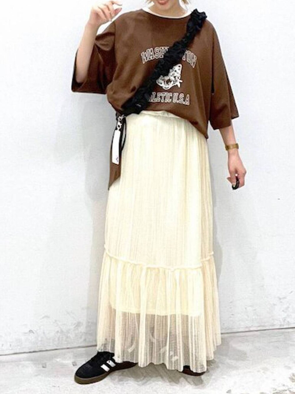 ホワイト系のタンクトップ、ブラック系のスニーカー、ブラック系のスマホグッズを着用したレディースの夏コーディネートの4枚目の写真