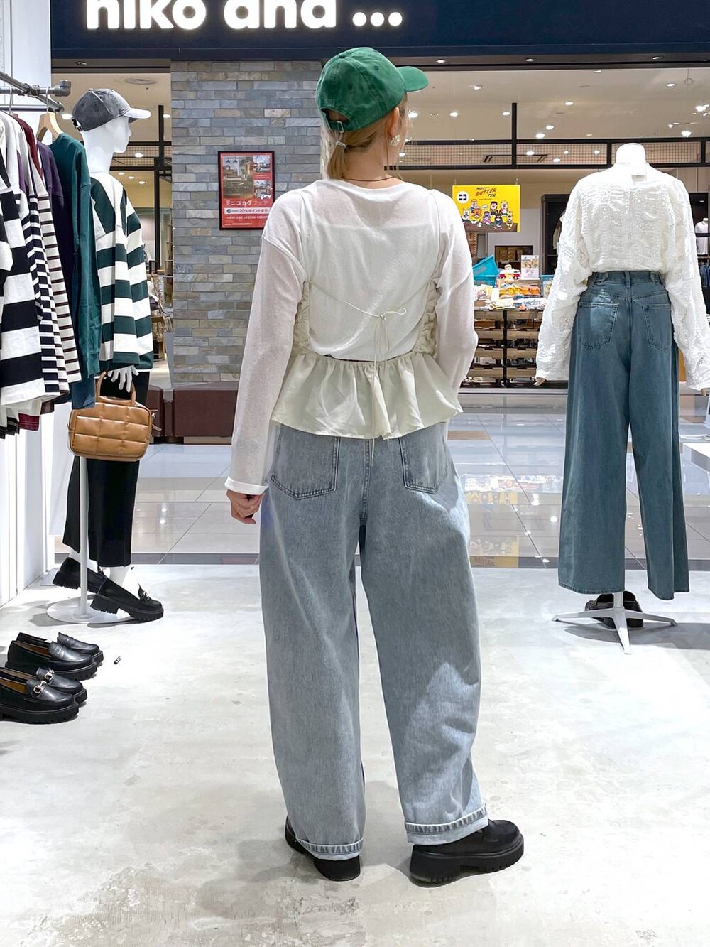 ホワイト系のTシャツ/カットソー、ブラック系のローファー、ブルー系のデニムパンツを着用したレディースの秋コーディネートの3枚目の写真