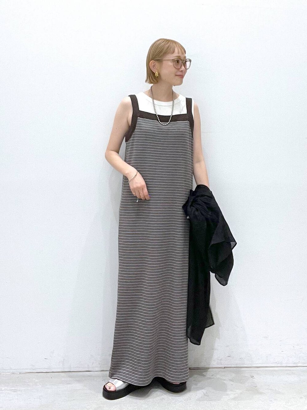ベージュ系のワンピース、シルバー系のサンダル、ホワイト系のタンクトップを着用したレディースの夏コーディネートの4枚目の写真