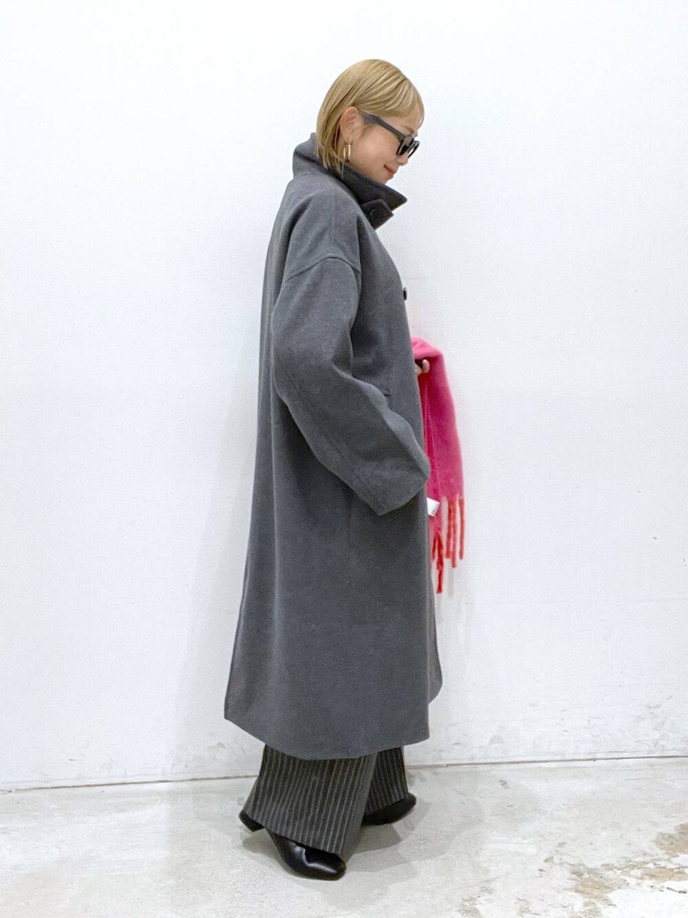 グレー系のその他アウター、ブラック系のブーツ、ブラック系のニット/セーターを着用したレディースの冬コーディネートの2枚目の写真