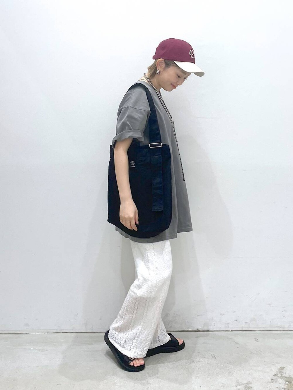ブラック系のサンダル、ブラック系のトートバッグ、グレー系のTシャツ/カットソーを着用したレディースの春コーディネートの2枚目の写真