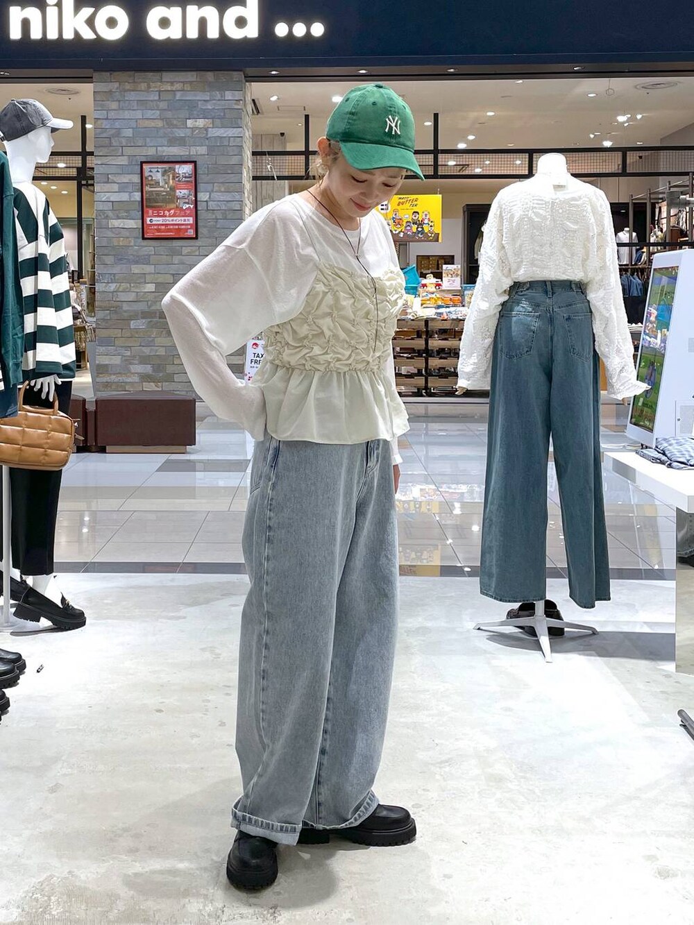 ホワイト系のTシャツ/カットソー、ブラック系のローファー、ブルー系のデニムパンツを着用したレディースの秋コーディネートの2枚目の写真