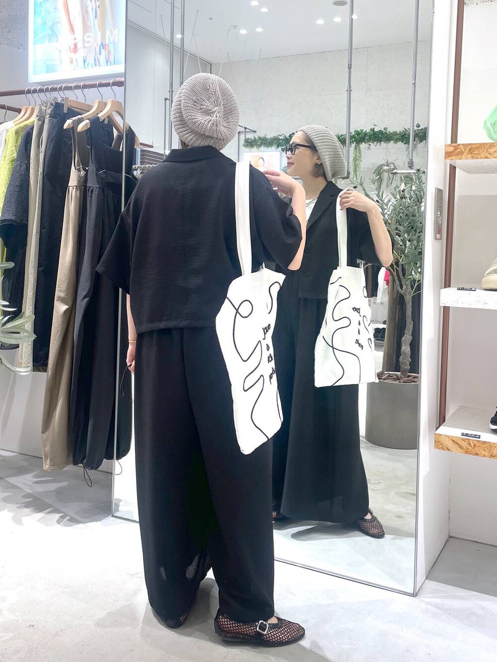 ブラック系のサロペット/オーバーオール、ブラック系のパンプス、ホワイト系のトートバッグを着用したレディースの夏コーディネートの2枚目の写真