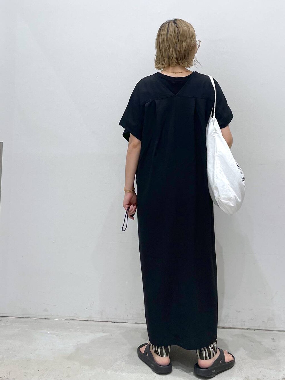 ブラック系のTシャツ/カットソー、ブラック系のワンピース、ホワイト系のショルダーバッグを着用したレディースの夏コーディネートの4枚目の写真