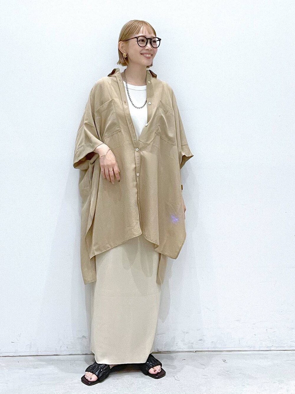 ブラック系のサンダル、ベージュ系のスカート、ベージュ系のチュニックを着用したレディースの夏コーディネートの4枚目の写真