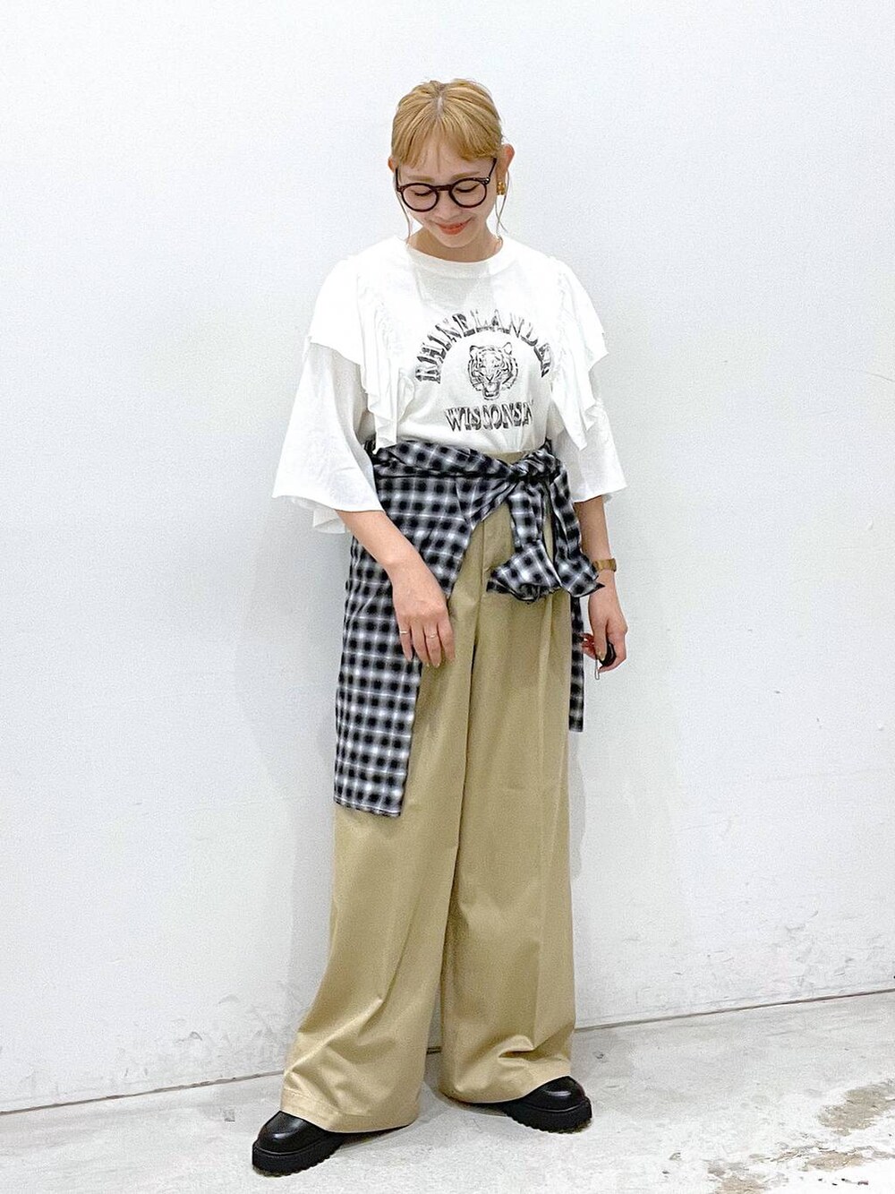 ベージュ系のチノパンツ、ブラック系のローファー、ホワイト系のTシャツ/カットソーを着用したレディースの夏コーディネートの4枚目の写真