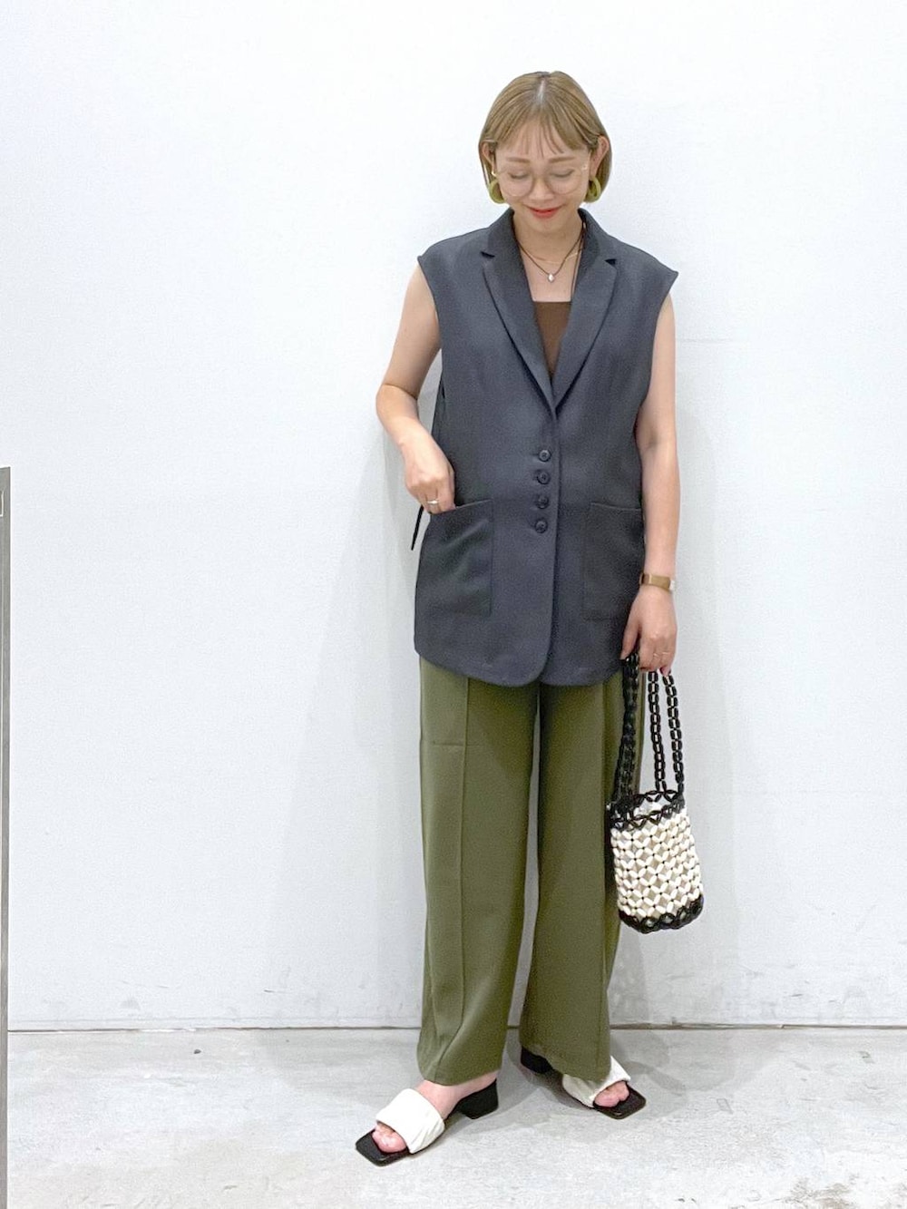 グリーン系のその他パンツ、ホワイト系のサンダル、ホワイト系のハンドバッグを着用したレディースの夏コーディネートの3枚目の写真